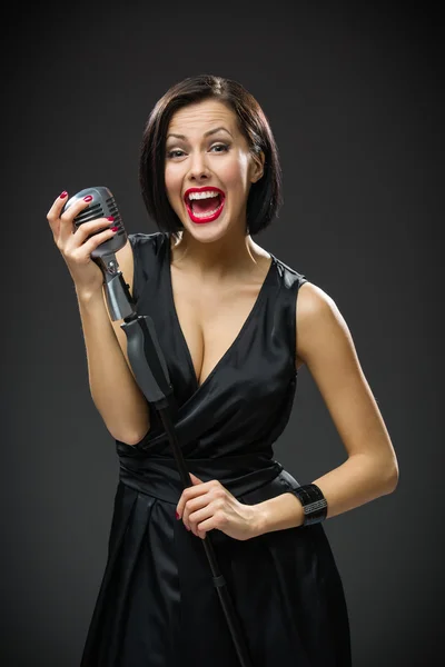 Female musician handing microphone — Stock Photo, Image