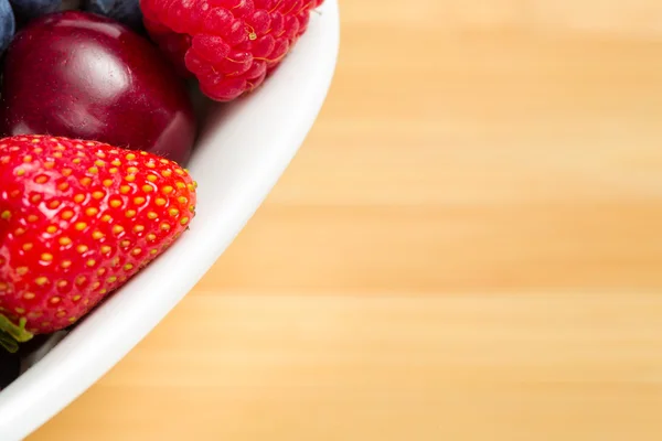 Close up shot of par of plate full of berries on table — Stock Photo, Image