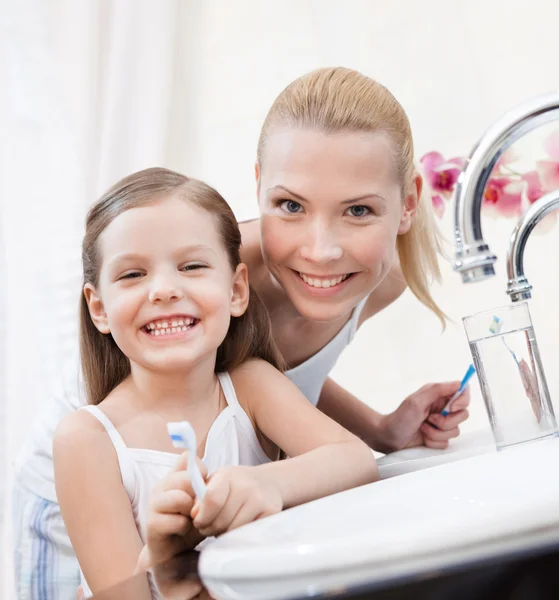 Kleines Mädchen putzt Zähne mit ihrer Mutter — Stockfoto