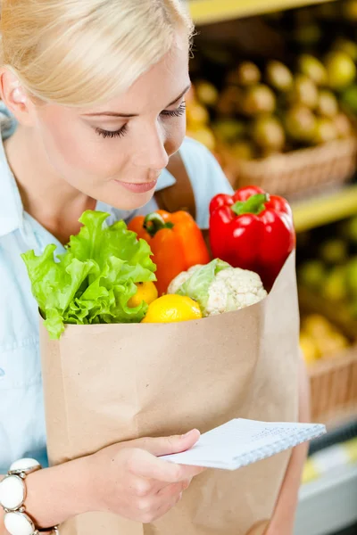 Lány tartja a csomagot, friss zöldségekkel — Stock Fotó