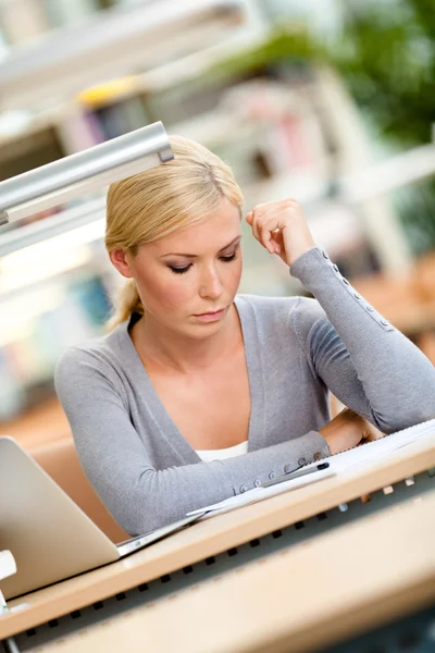 Vrouwelijke student lezen aan de tafel — Stockfoto