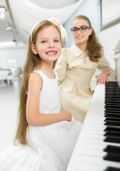 Tutor de música ensina a menina a tocar piano — Fotografia de Stock