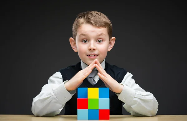 Pojke bygga hus från mångfärgade tegelstenar — Stockfoto