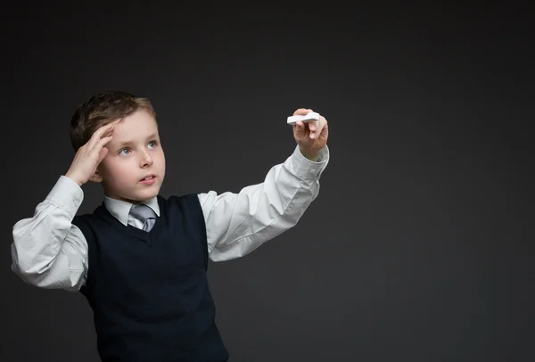 Nachdenklicher kleiner Junge schreibt etwas mit Kreide — Stockfoto