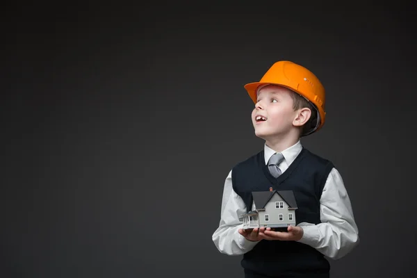 Menino de chapéu duro mantendo modelo em casa — Fotografia de Stock