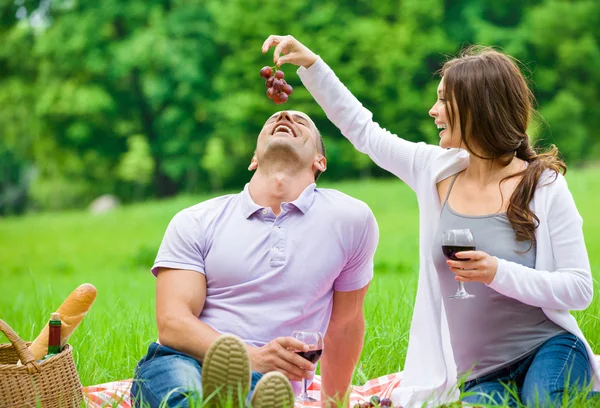 Mujer alimenta al hombre en el parque — Foto de Stock