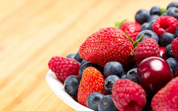 Close up of plate full of berries on table — Stock Photo, Image