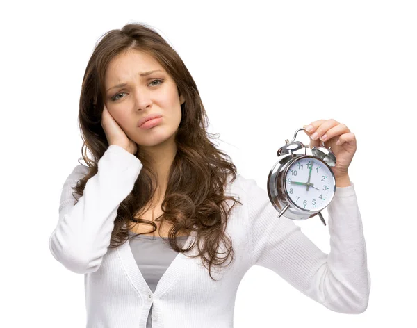 Tired woman handing alarm clock — Stock Photo, Image