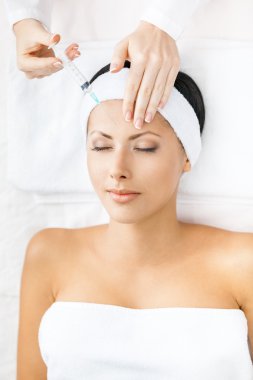 Kız enjeksiyonları yüzünde alır.