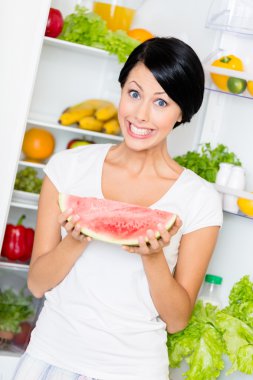 kadın karpuz açılan buzdolabından alır.