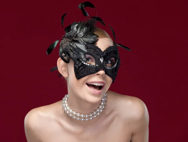 Jonge vrouw met zwarte maskerade masker met veren — Stockfoto