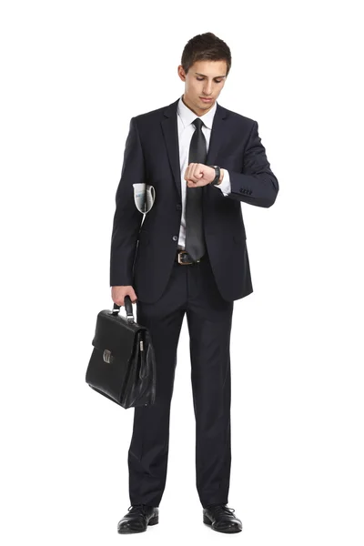 Businessman handing briefcase and looking at his watch — Stock Photo, Image