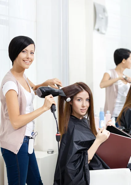 Peluquería hace el estilo de pelo de la mujer en el salón de peluquería —  Fotos de Stock