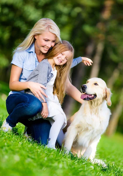 Anne ve kızı ile labrador geri almak çimlere vardır — Stok fotoğraf