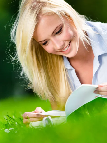 Linda chica leyendo libro en la hierba —  Fotos de Stock