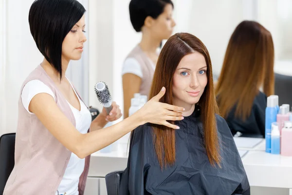 Hair stylist does hair style of woman — Stock Photo, Image