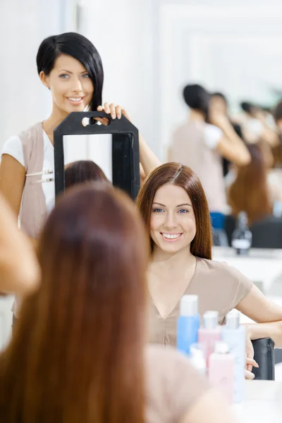Hair stylist showing the hairstyle of client — Stock Photo, Image