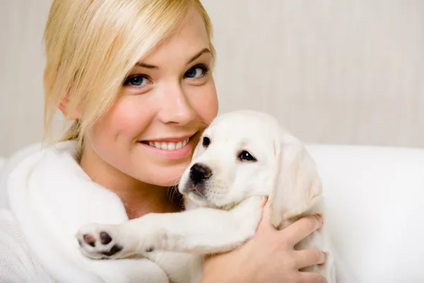 女人抱着一只拉布拉多小狗 — 图库照片