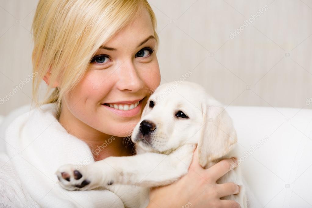 Woman holds a Labrador puppy