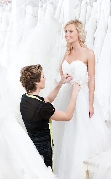 Seamstress measures waist of the bride — Stock Photo, Image