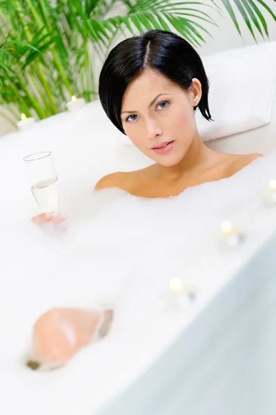 Woman taking a bath drinks wine — Stock Photo, Image