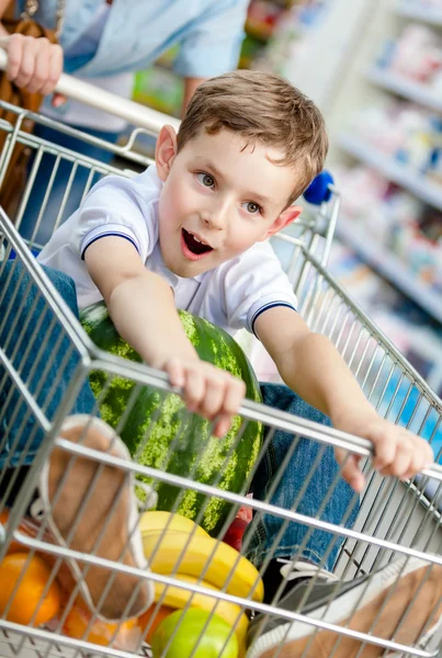Junge sitzt mit Wassermelone im Einkaufswagen — Stockfoto