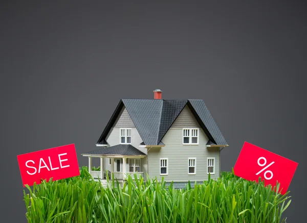 草和销售平板电脑的房子模型的特写 — 图库照片