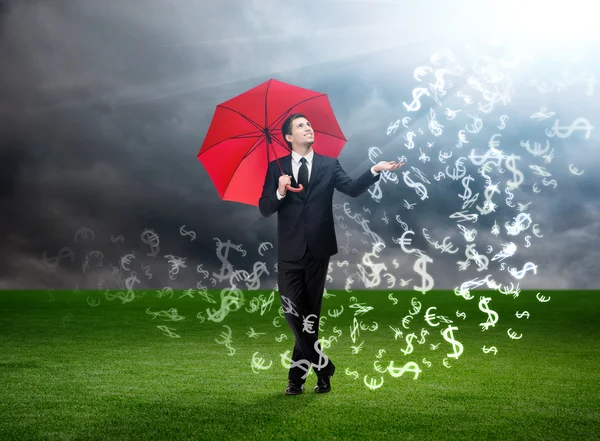 Hombre con paraguas rojo y señales de moneda cayendo del cielo — Foto de Stock