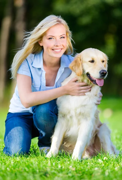 Женщина с собакой сидит на траве — стоковое фото
