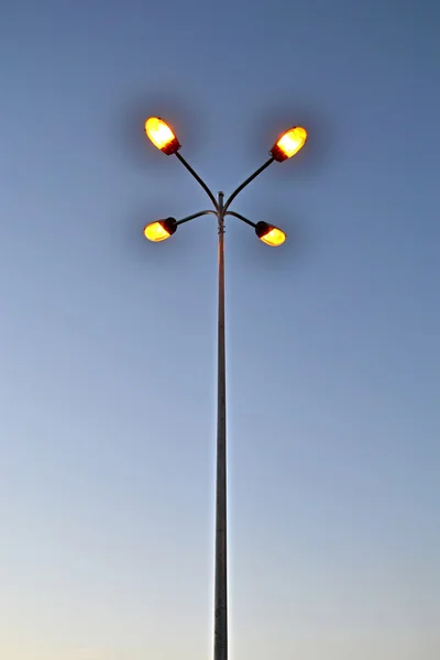 Weinig gele Opwindbare lamp op hoge metalen pyloon, elektriciteit. — Stockfoto