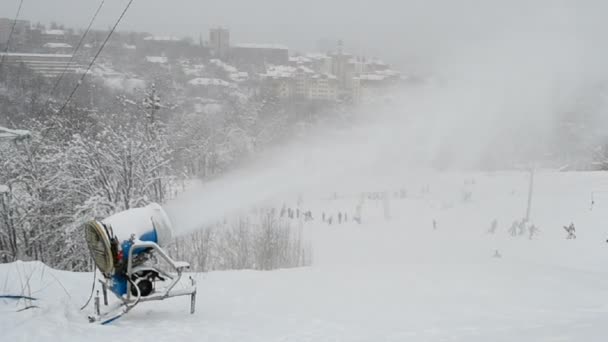 Snow gun (pulverizer) disperse artificial snow on mountain, winter. — Stock Video