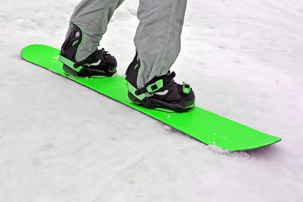 Grön snowboard på vit snö, säsongsbetonad sport . — Stockfoto