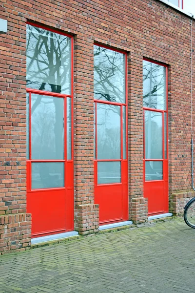 Rote Türen an der Ziegelwand, Bauindustrie. — Stockfoto