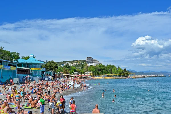 Crimée station balnéaire, les gens sur la plage publique de galets, Mer Noire à Aloushta, Ukraine . — Photo