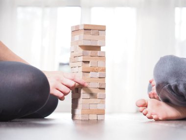 Anne ve çocuk evde Jenga oynuyorlar.