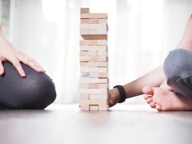 Anne ve çocuk evde Jenga oynuyorlar.