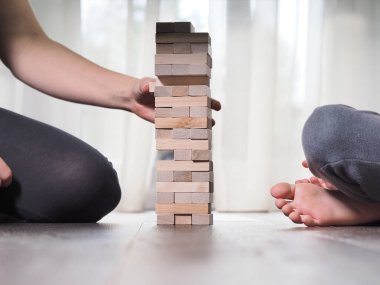 Anne ve çocuk evde Jenga oynuyorlar.
