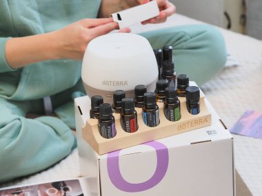 Genç kadın bir sağlık konferansında bir kutu Doterra 'nın gerekli yağlarını açıyor. Belarus, Minsk, 2021.