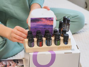 Genç kadın bir sağlık konferansında bir kutu Doterra 'nın gerekli yağlarını açıyor. Belarus, Minsk, 2021.