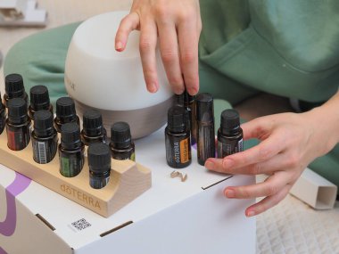 Genç kadın bir sağlık konferansında bir kutu Doterra 'nın gerekli yağlarını açıyor. Belarus, Minsk, 2021.