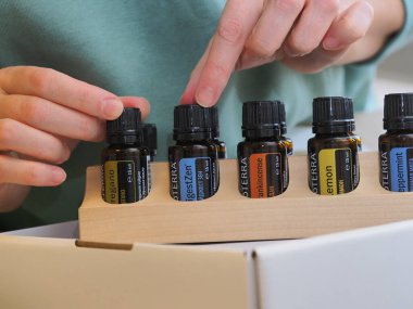 Genç kadın bir sağlık konferansında bir kutu Doterra 'nın gerekli yağlarını açıyor. Belarus, Minsk, 2021.