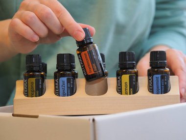 Genç kadın bir sağlık konferansında bir kutu Doterra 'nın gerekli yağlarını açıyor. Belarus, Minsk, 2021.