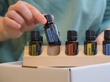 Genç kadın bir sağlık konferansında bir kutu Doterra 'nın gerekli yağlarını açıyor. Belarus, Minsk, 2021.