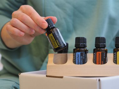 Genç kadın bir sağlık konferansında bir kutu Doterra 'nın gerekli yağlarını açıyor. Belarus, Minsk, 2021.