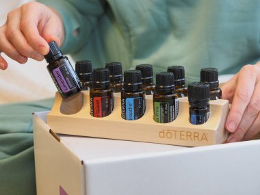 Genç kadın bir sağlık konferansında bir kutu Doterra 'nın gerekli yağlarını açıyor. Belarus, Minsk, 2021.