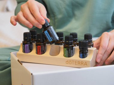 Genç kadın bir sağlık konferansında bir kutu Doterra 'nın gerekli yağlarını açıyor. Belarus, Minsk, 2021.