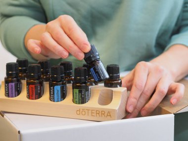 Genç kadın bir sağlık konferansında bir kutu Doterra 'nın gerekli yağlarını açıyor. Belarus, Minsk, 2021.