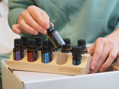 Genç kadın bir sağlık konferansında bir kutu Doterra 'nın gerekli yağlarını açıyor. Belarus, Minsk, 2021.