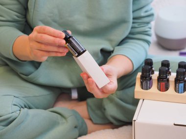 Genç kadın bir sağlık konferansında bir kutu Doterra 'nın gerekli yağlarını açıyor. Belarus, Minsk, 2021.
