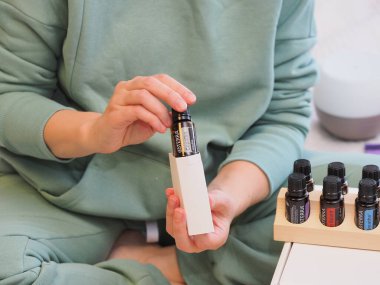 Genç kadın bir sağlık konferansında bir kutu Doterra 'nın gerekli yağlarını açıyor. Belarus, Minsk, 2021.